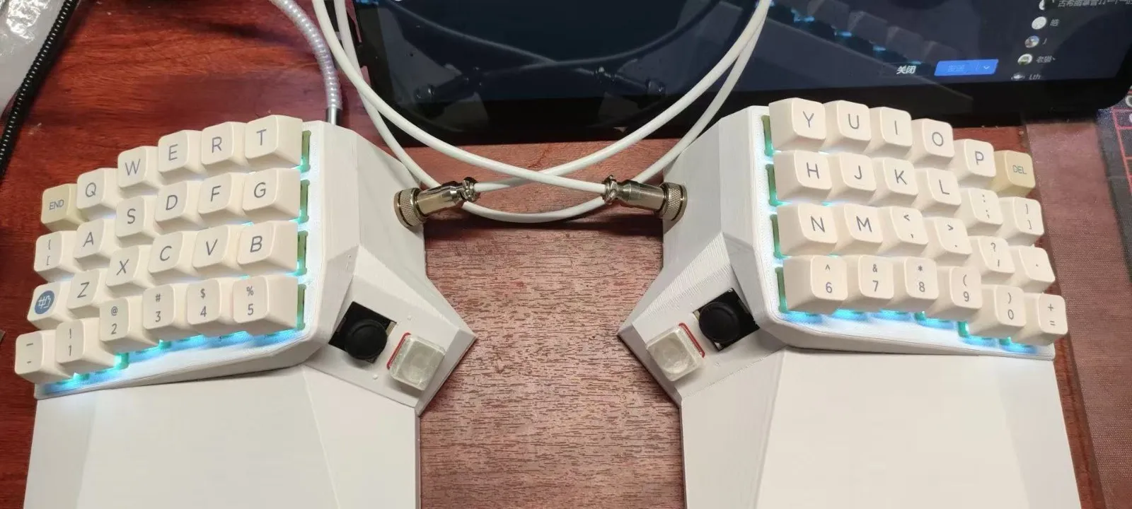 White OS Keyboard with cyan lighting on a wooden desk