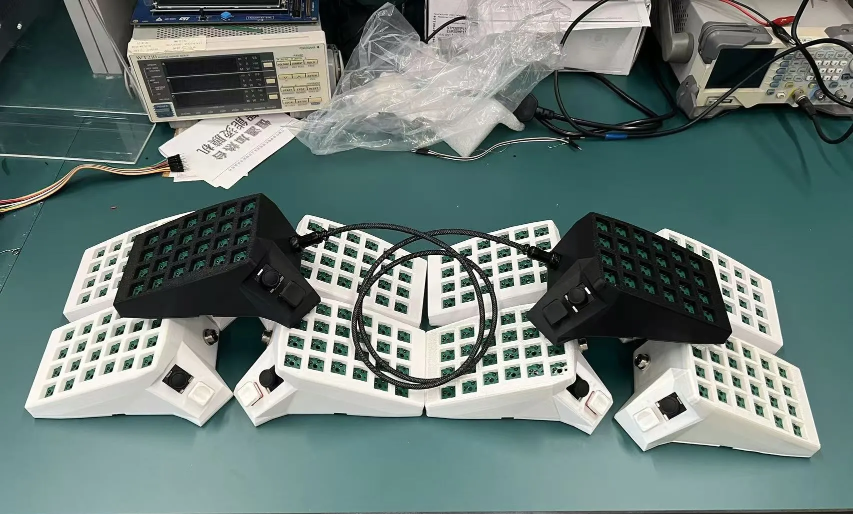 Two prototype halves with bare PCBs on a workbench